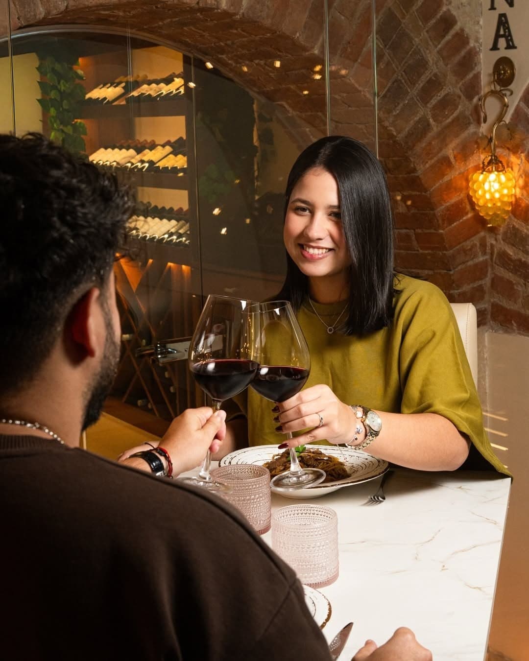 Pareja brindando con vino tinto en NAO Habana
